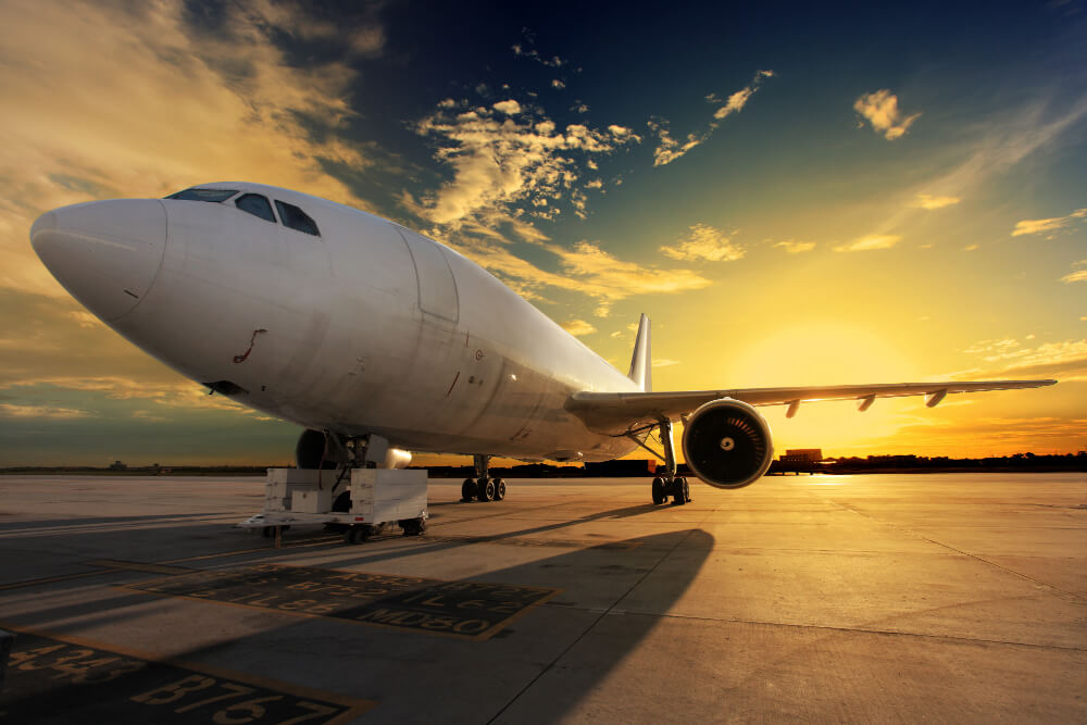 Airplane at airport during sunset, representing seamless airport transfers with BAWA GUEST HOUSE